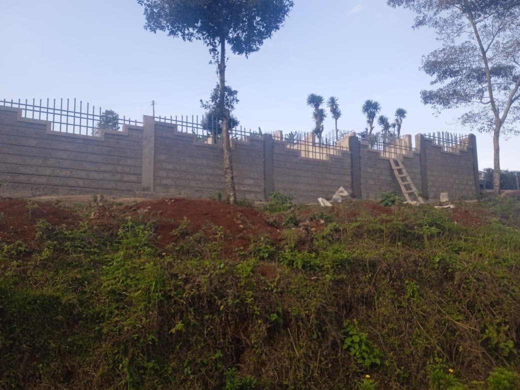 Perimeter wall with metal fencing spikes under construction