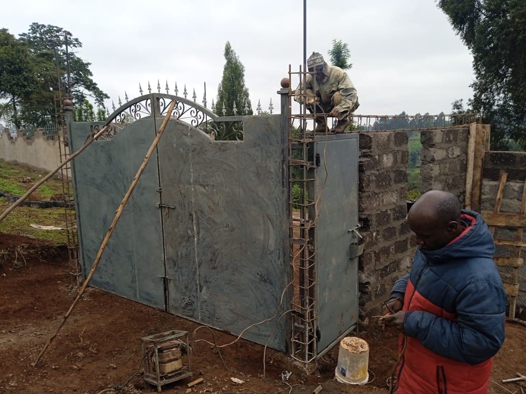 Ornate metal gate being installed with decorative scrollwork