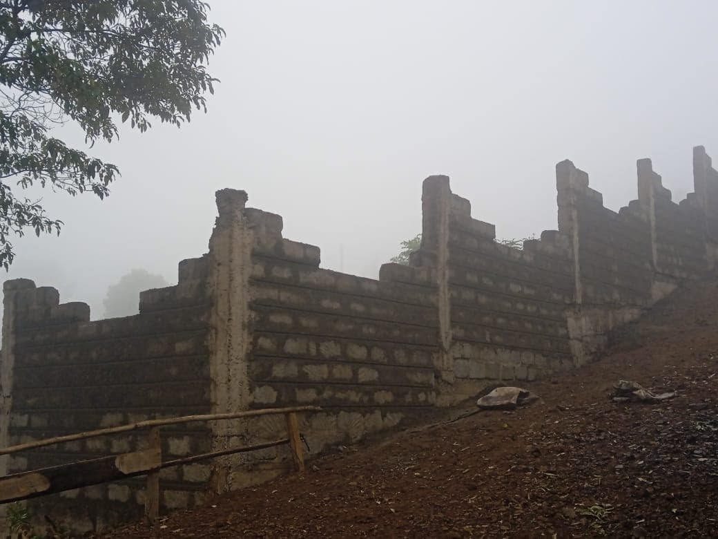 Misty morning view of stepped perimeter wall construction with pillars in foggy atmosphere