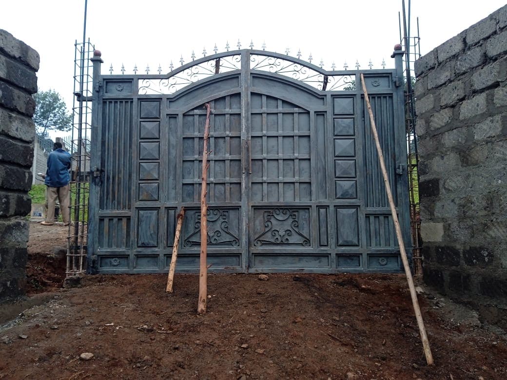 Completed ornate main entrance gate with arched design and decorative scrollwork