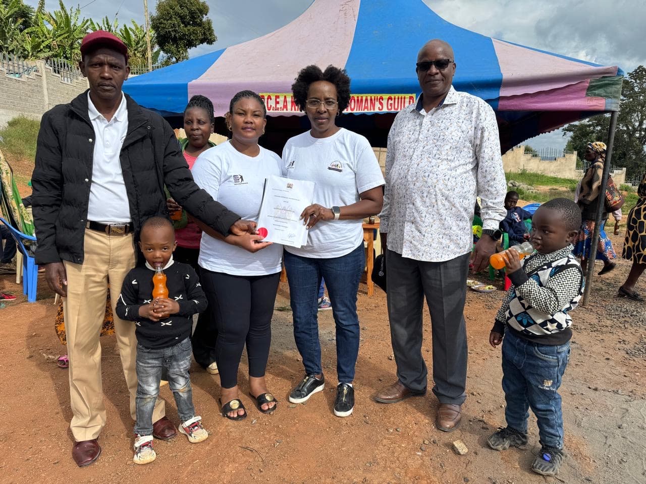 Family group photo with certificate presentation at community event