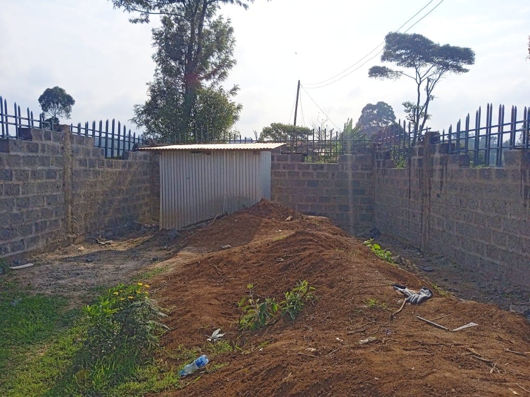 Interior view showing perimeter walls with metal railings on both sides and white corrugated storage structure