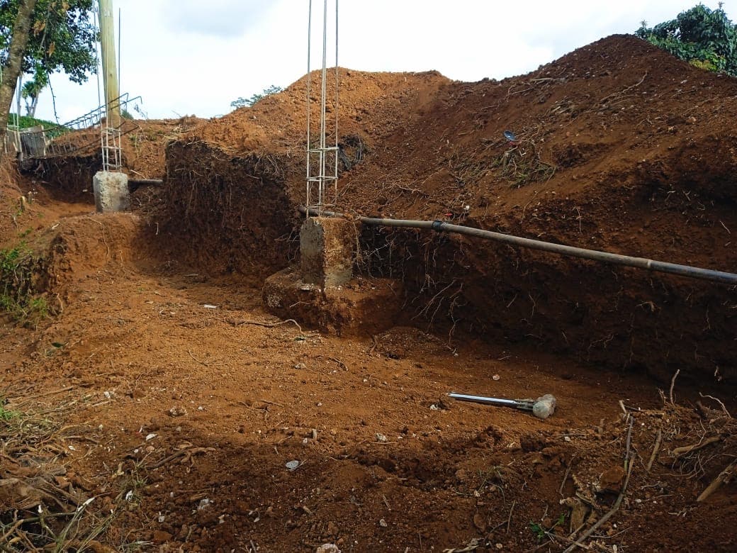 Excavation site with reinforcement columns and piping infrastructure