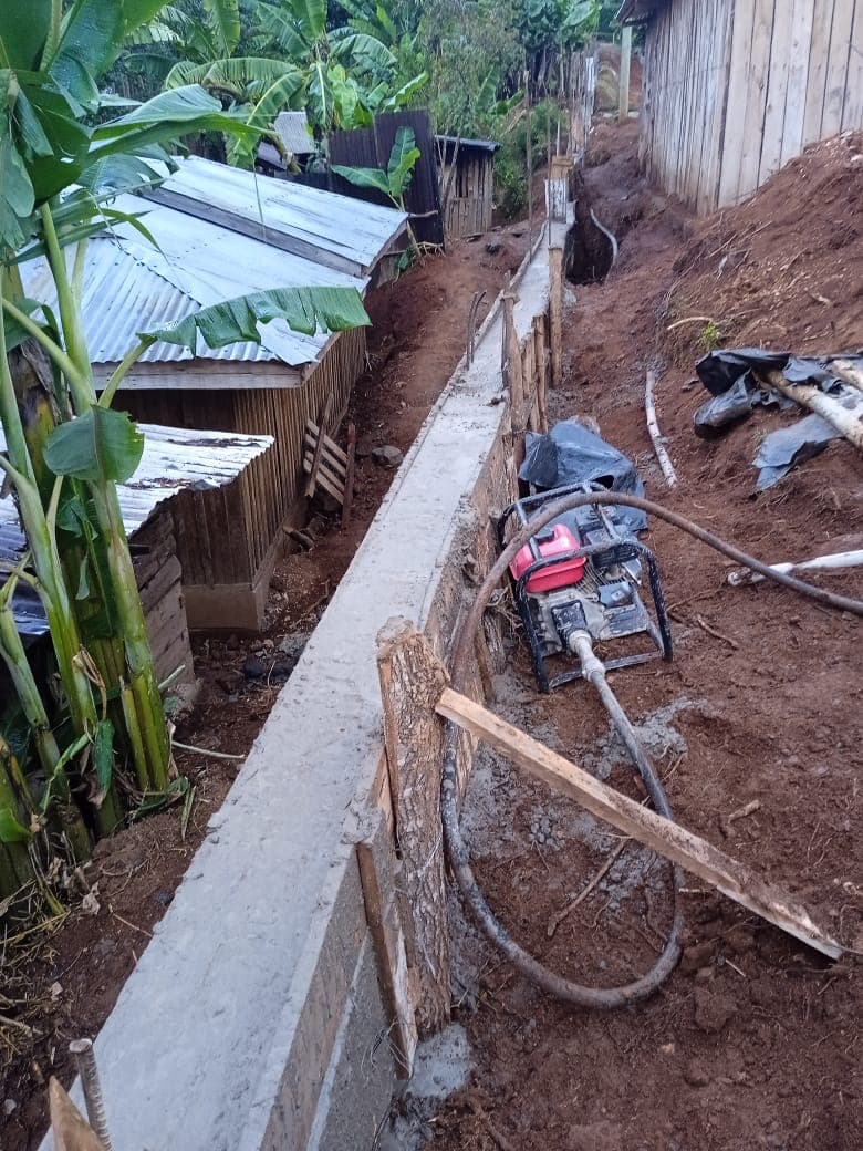 Concrete retaining wall being poured with generator pump